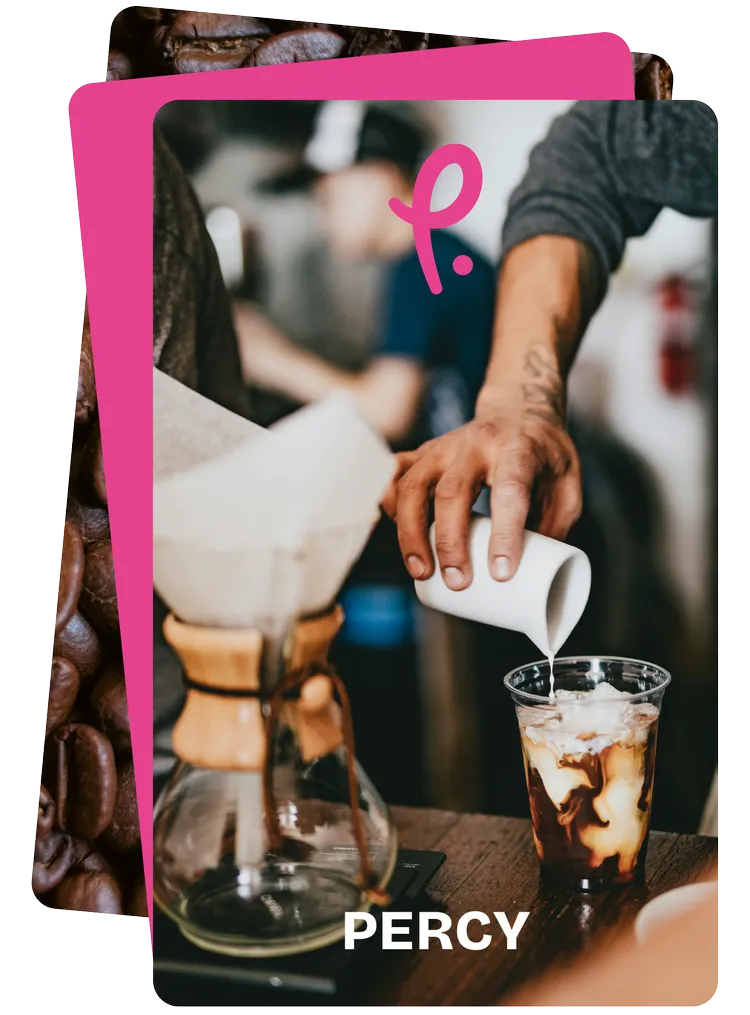 A barista pouring milk into an iced coffee