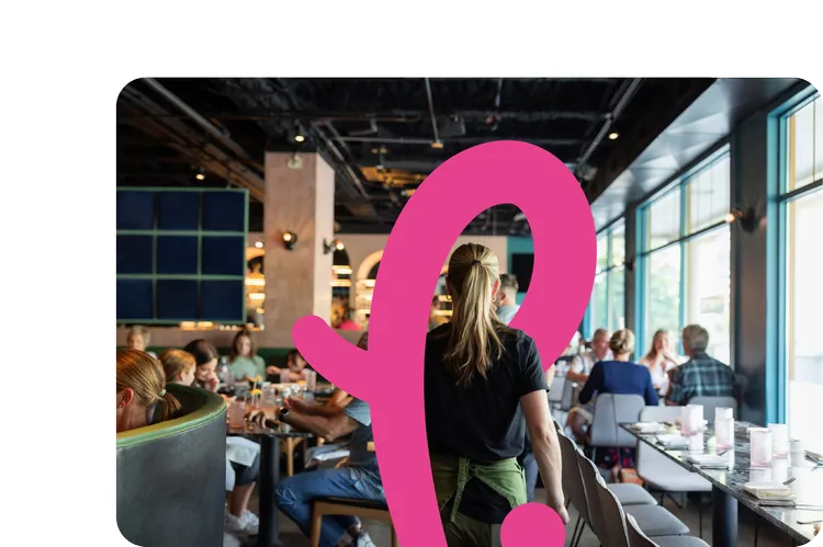 A server walking through a busy restaurant dining room at service